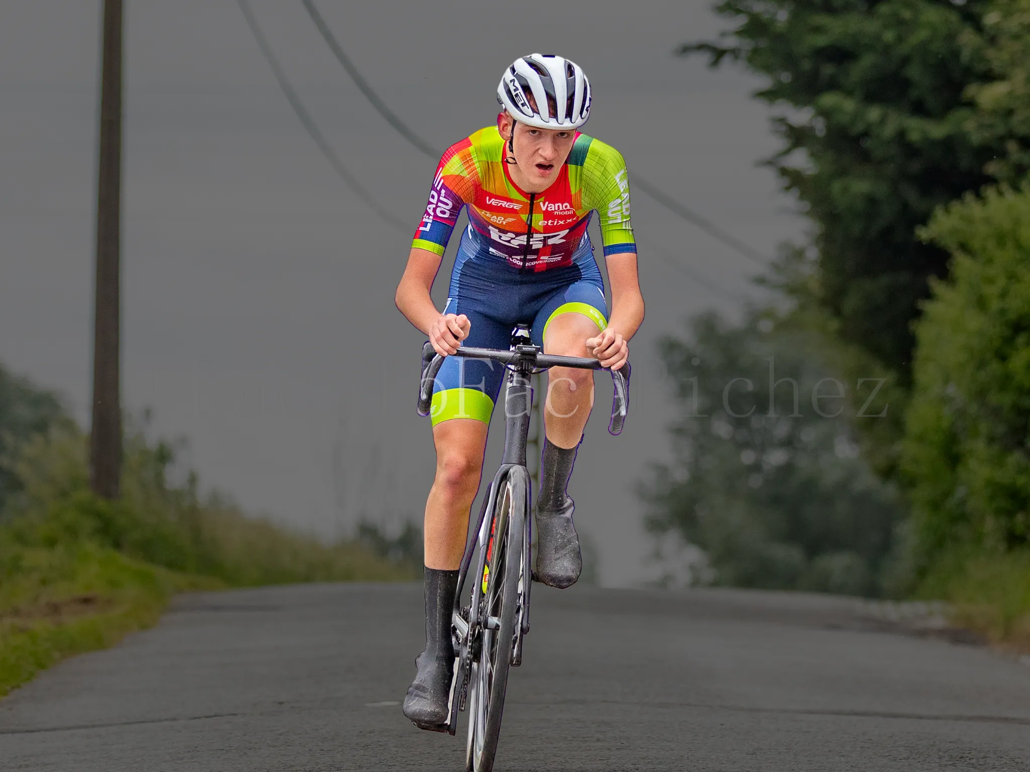 Xander racing solo on an open road in team kit.