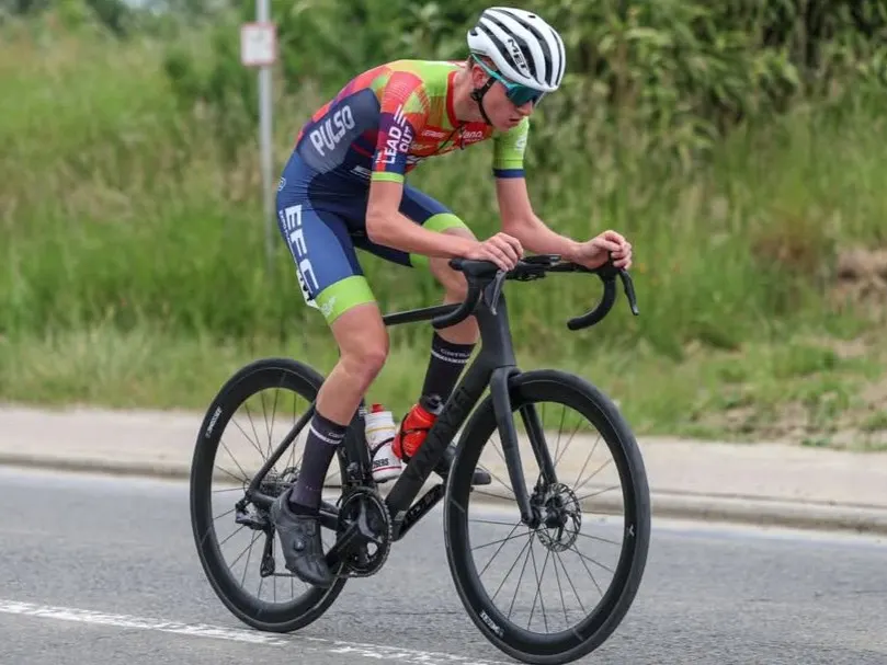 Xander riding along an open road in a colourful Pulso EFC team kit.